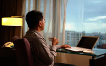 man sitting at desk looking out window